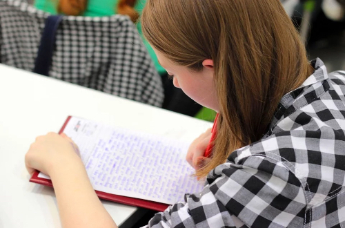 Studentka notująca w zeszycie.