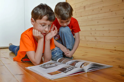 Dwójka dzieci czyta książkę